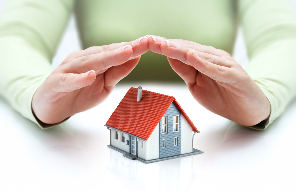 Document Management in Insurance. house covered of woman hands - protect and insurance real estate concept